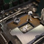 Miniaturas de investigadores examinando um processador de computador durante uma investigação digital