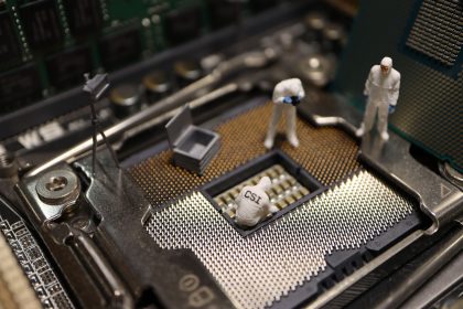 Miniaturas de investigadores examinando um processador de computador durante uma investigação digital