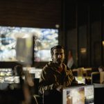 Equipe monitora imagens de vigilância em uma moderna central de controle de segurança.