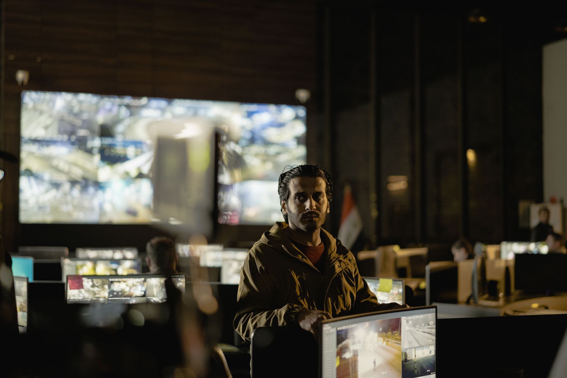 Equipe monitora imagens de vigilância em uma moderna central de controle de segurança.